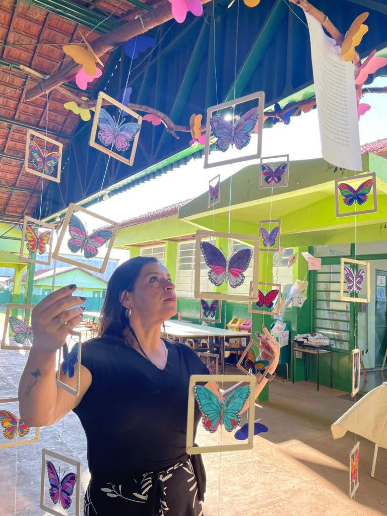 mulher entre quadros com borboletas.