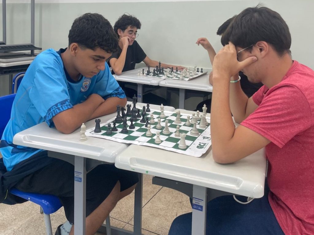 Estudantes jogando xadrez dutante competição.