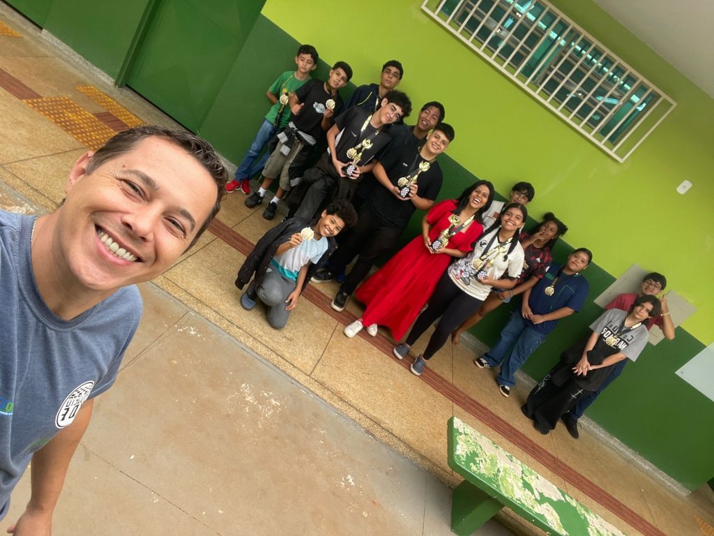 Professor e estudantes do projeto de xadrez.