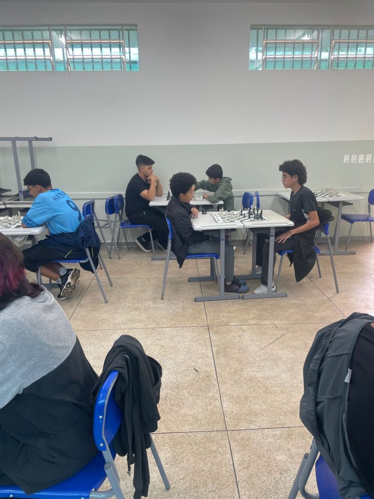 Estudantes jogando xadrez durante campeonato.
