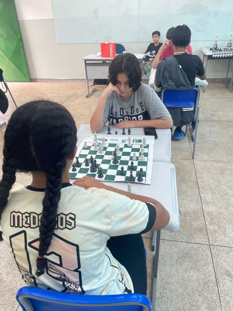 Estudantes jogando xadrez durante campeonato.