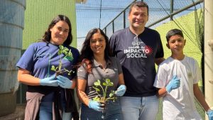 Diretor, voluntários e estudantes com hortaliças.