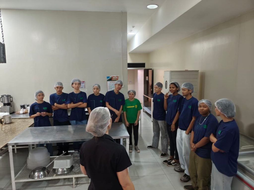 Estudantes na cozinha recebendo informações.