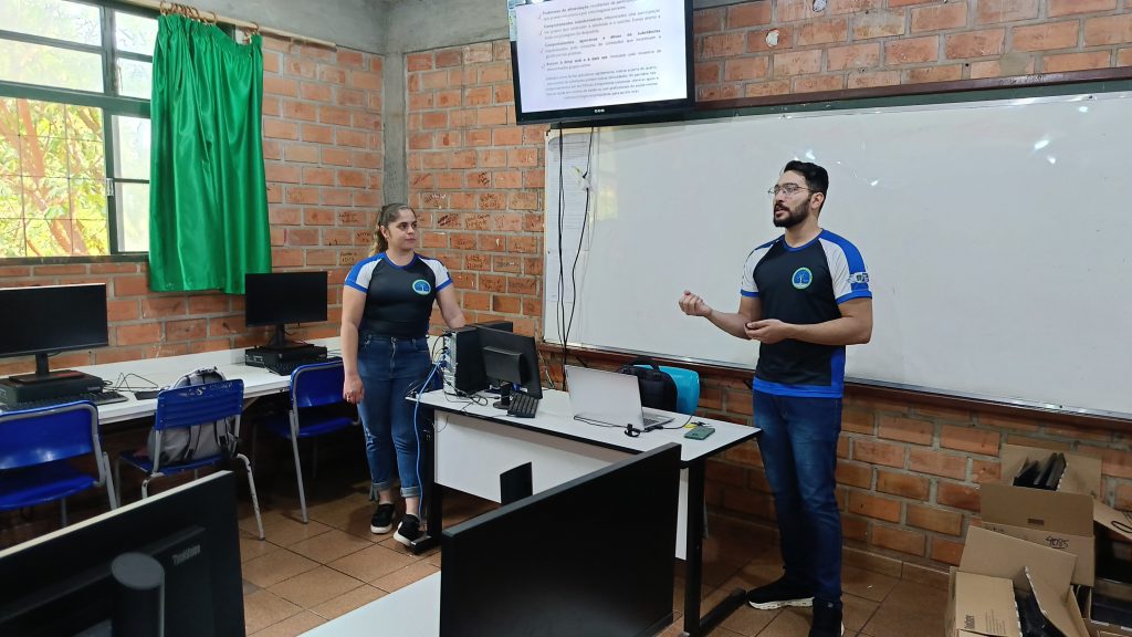 Os professores Kennedy dos Santos Silva e Brenda Medina de Oliveira orientaram os pais dos alunos sobre o uso consciente da tecnologia na Feira do Conhecimento da EE Alício Araújo