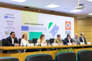 Pessoas na mesa com fundo escrito Mato Grosso do Sul.