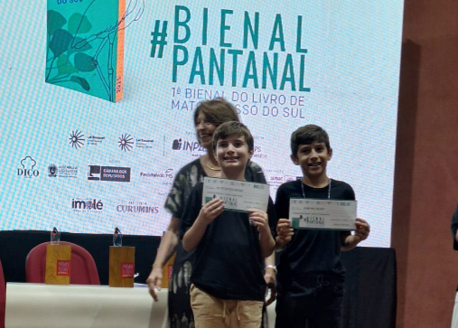 Dois estudantes com certificados nas mãos.