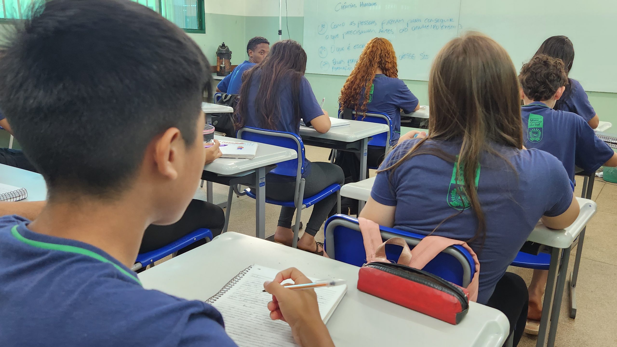 Imagem destacada de estudantes em sala de aula.